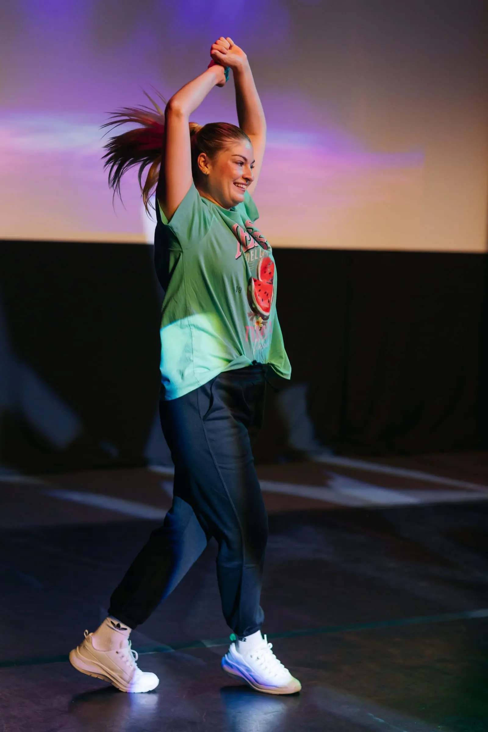 A dancer in trainers performing a street and commercial routine on stage