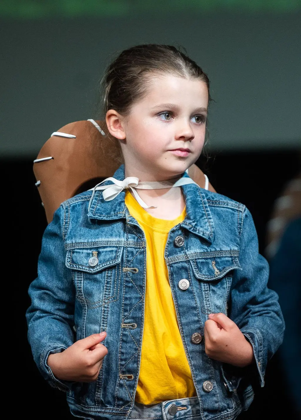 A young Dancemania dancer in a denim jacket performing on stage